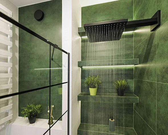 A custom shower featuring elegant green tiles, combining unique style with high-end craftsmanship for a spa-like experience.