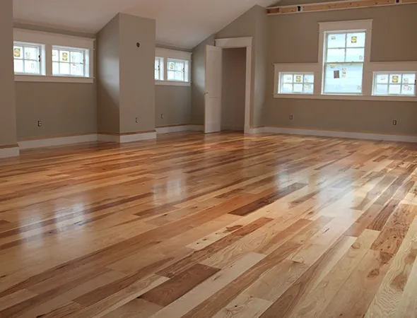 A bright, empty room with light wooden flooring, offering a clean and spacious look ready for personalization.