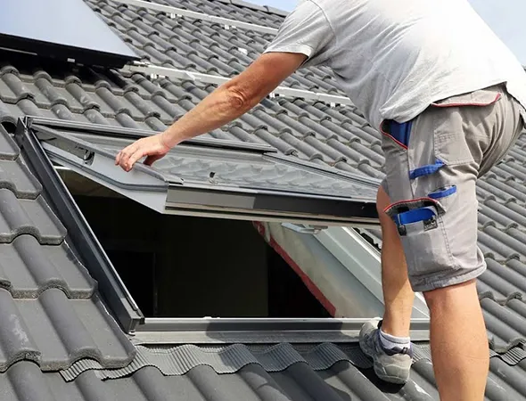 A man carefully installing a skylight on the roof, ensuring a secure fit for optimal natural light and insulation.